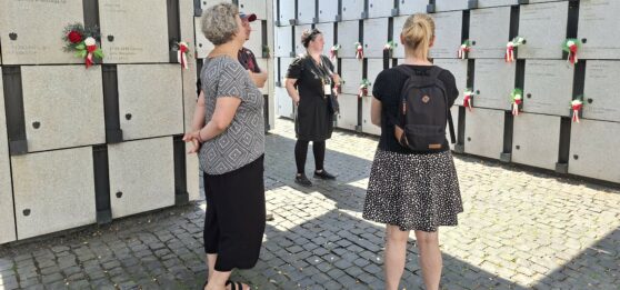 Przewodnik z uczestnikami spaceru zwiedzają Panteon – Mauzoleum Wyklętych-Niezłomnych na Cmentarzu Wojskowym na Powązkach